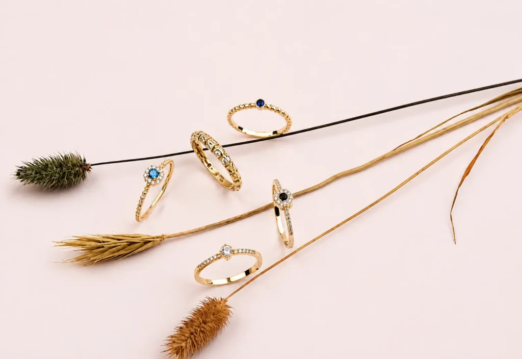Gold anti tarnish jewellery rings styled with dried botanicals on a pink backdrop.